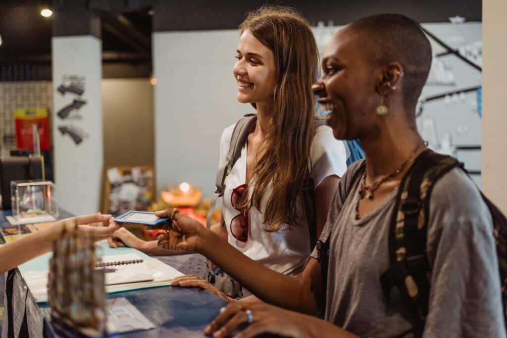 Women Receiving a Hotel Room Card at the Reception Desk 